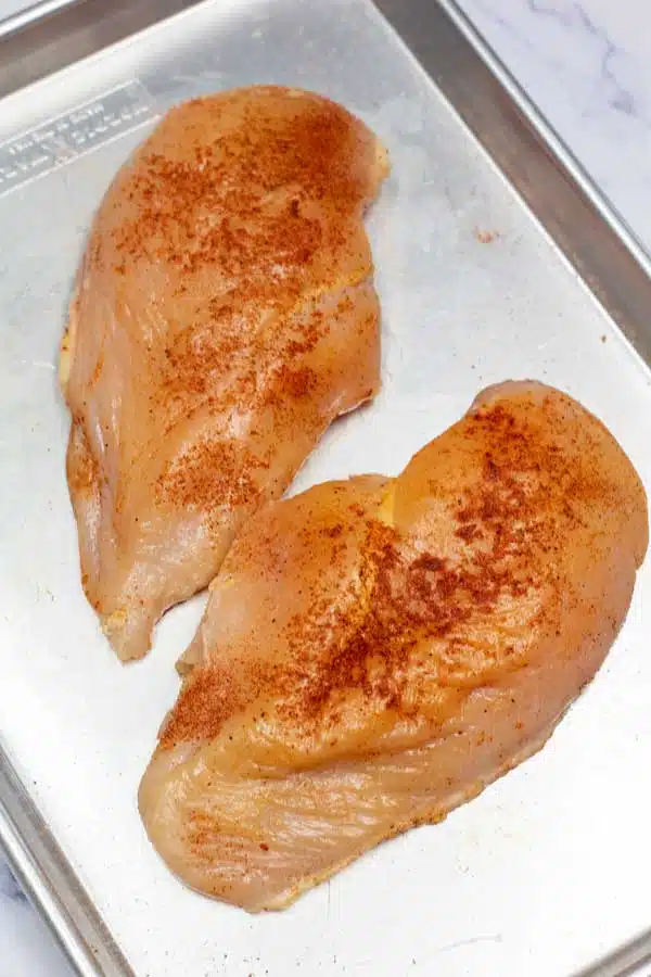Process image 1 showing seasoned boneless skinless chicken breasts.