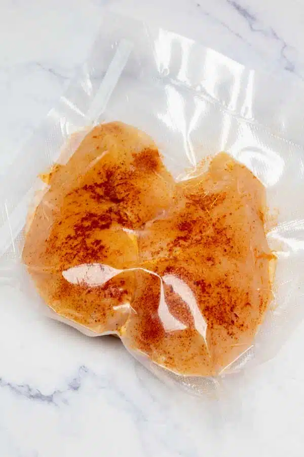 Process image 2 showing seasoned boneless skinless chicken breasts in sealed bag.