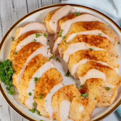 Square image showing sliced sous vide boneless skinless chicken breast.