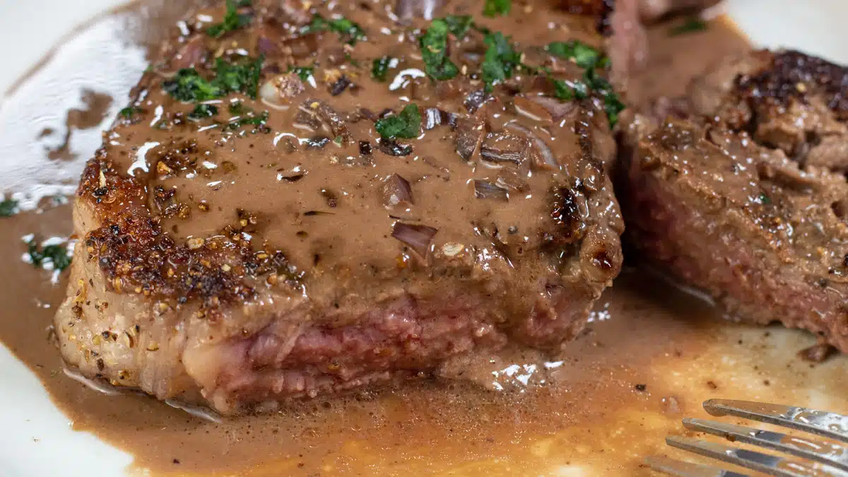 Wide image showing steak au poivre.