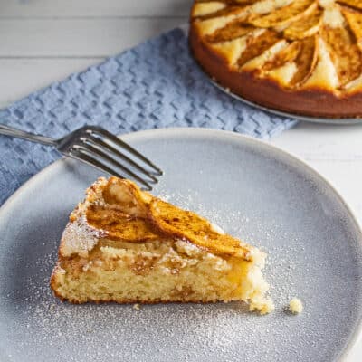 Najbolji nizozemski recept za kolač od jabuka pečen do zlatne savršenosti i preliven nježnim jabukama s cimetom, narezan na kriške i poslužen.