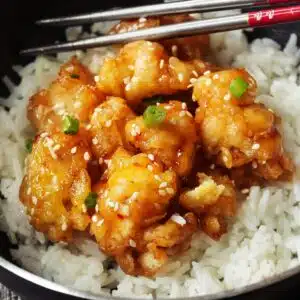 Square image of honey sesame chicken and rice.