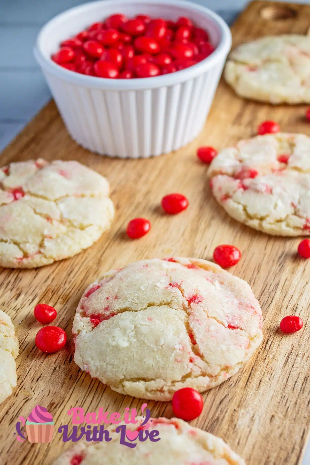 Tender red hot cookies on wooden serving tray with a bowl of more candies to snack on.