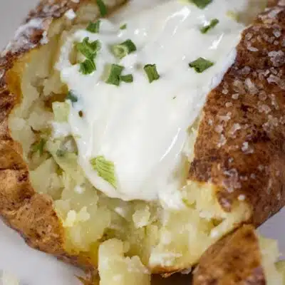 Pin image with text of air fryer baked potato with sour cream and chives.
