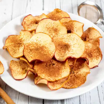 Square image of a plate of baked cinnamon apple chips.