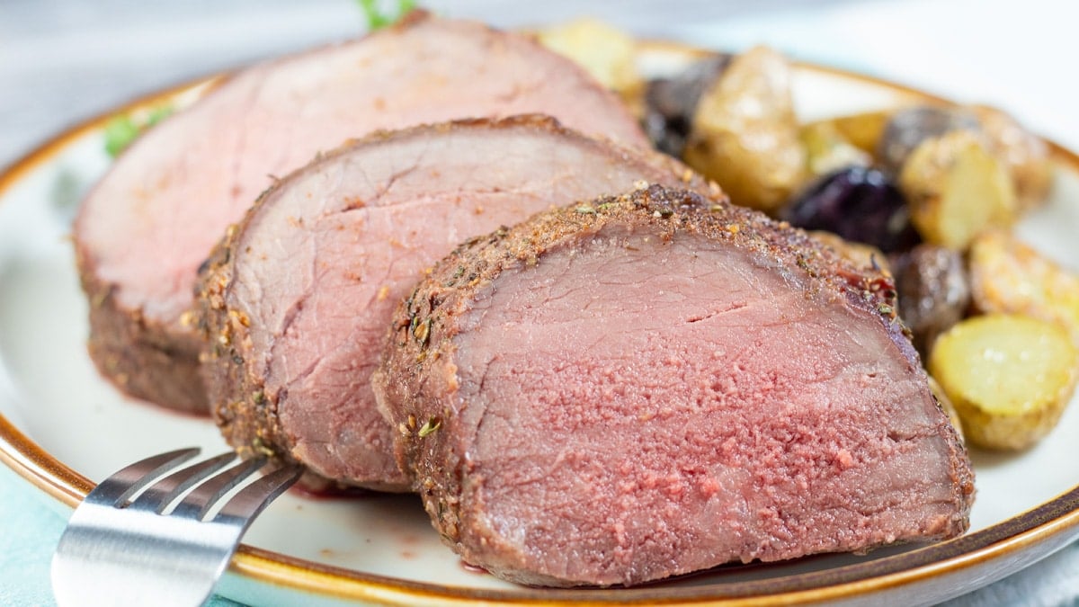 Wide image of sliced beef top round roast.