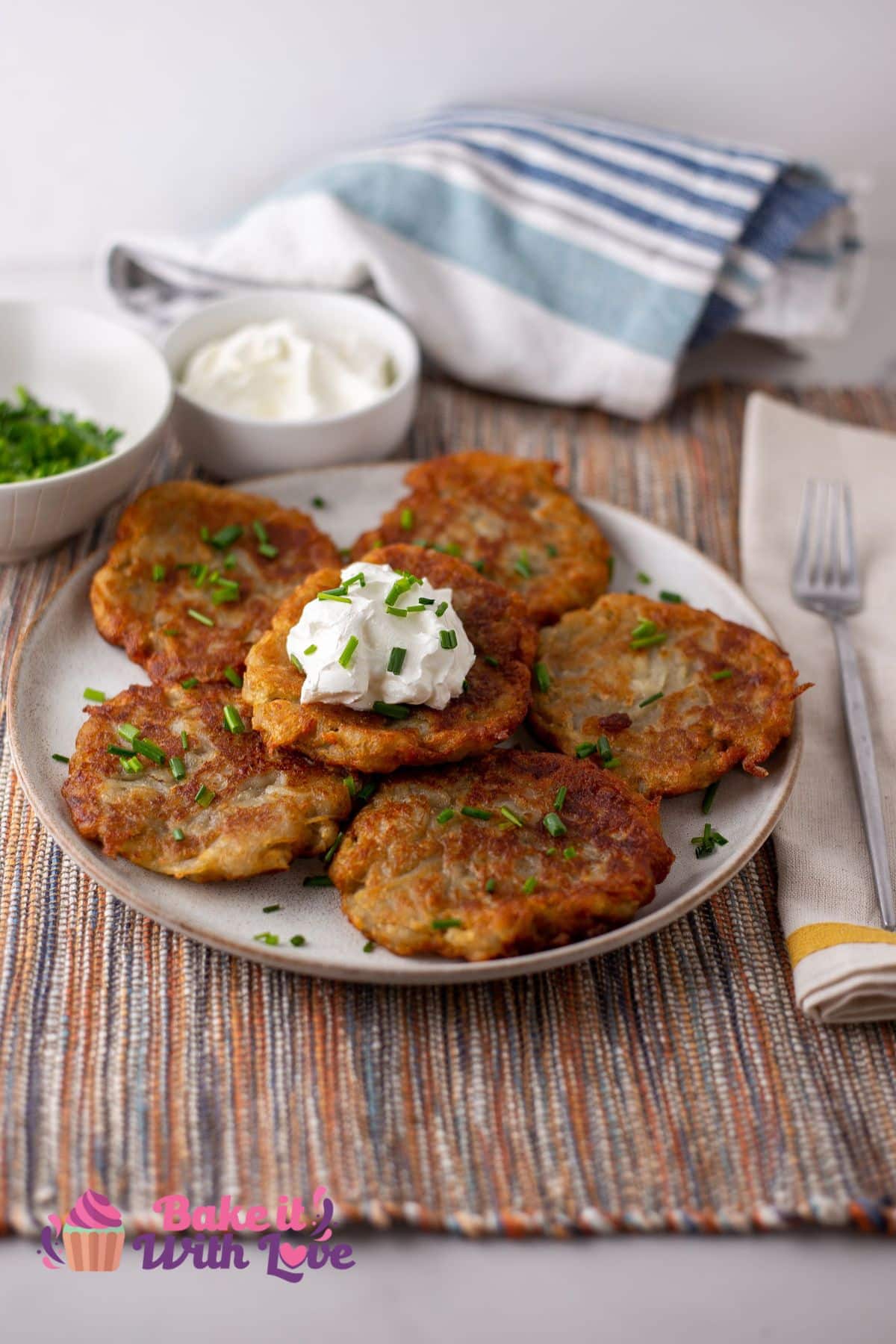 Tall image showing boxty Irish pancakes on a plate, topped with sour cream and green onions.