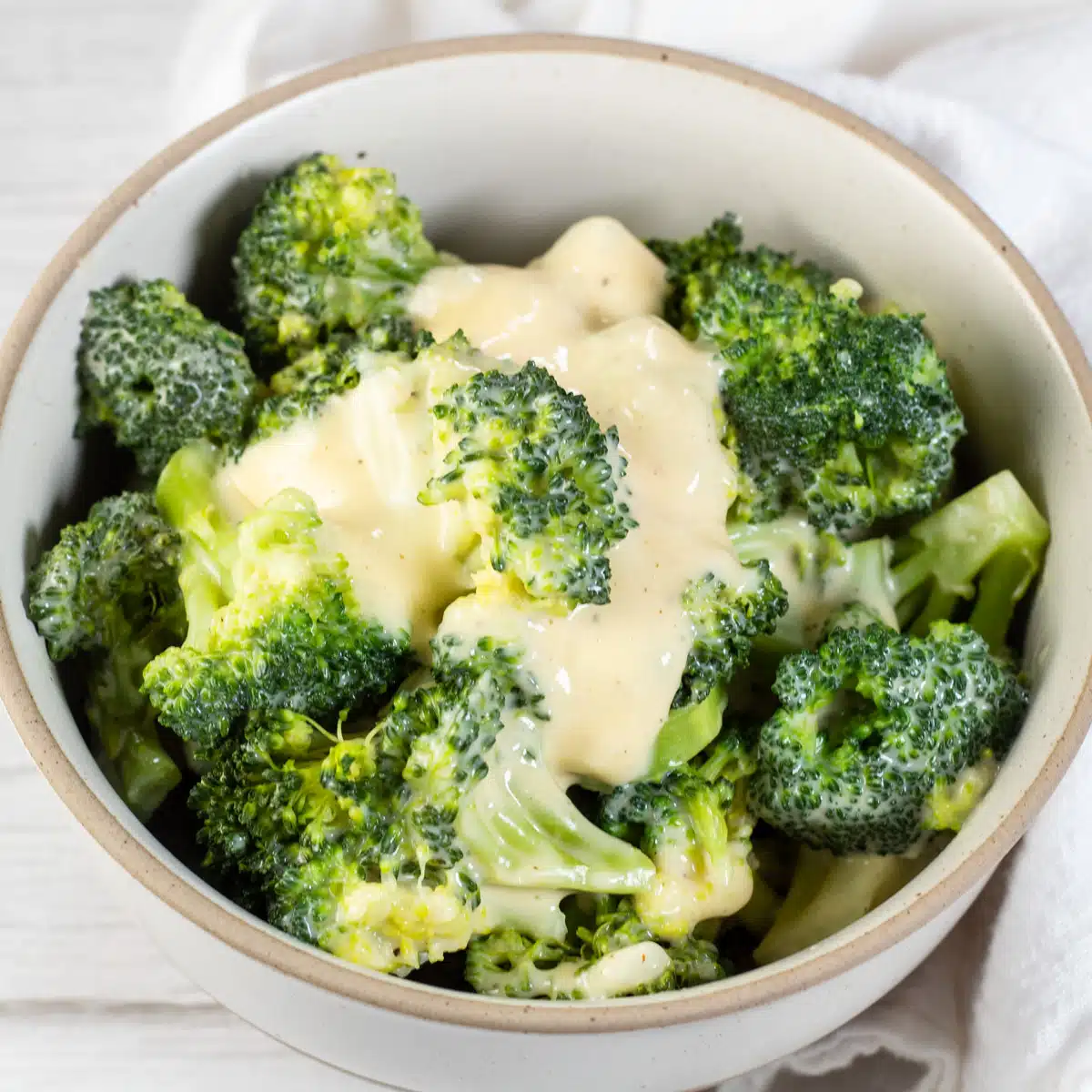 Firkantet billede, der viser broccoli og ost.