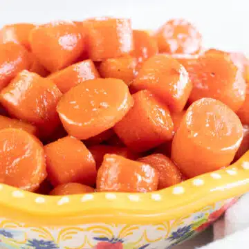 Wide image of a bowl of candied carrots.