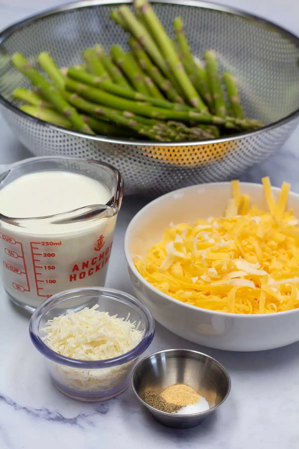 Tall image of cheesy baked asparagus ingredients.