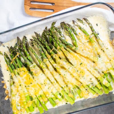 Square image of cheesy baked asparagus.