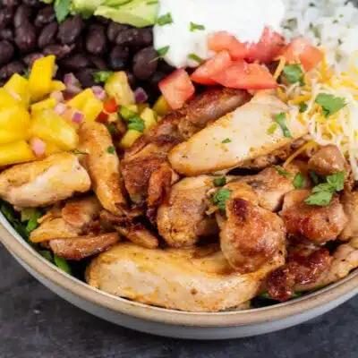 Best chicken burrito bowl recipe pin with the loaded burrito bowl on dark background and text title footer.