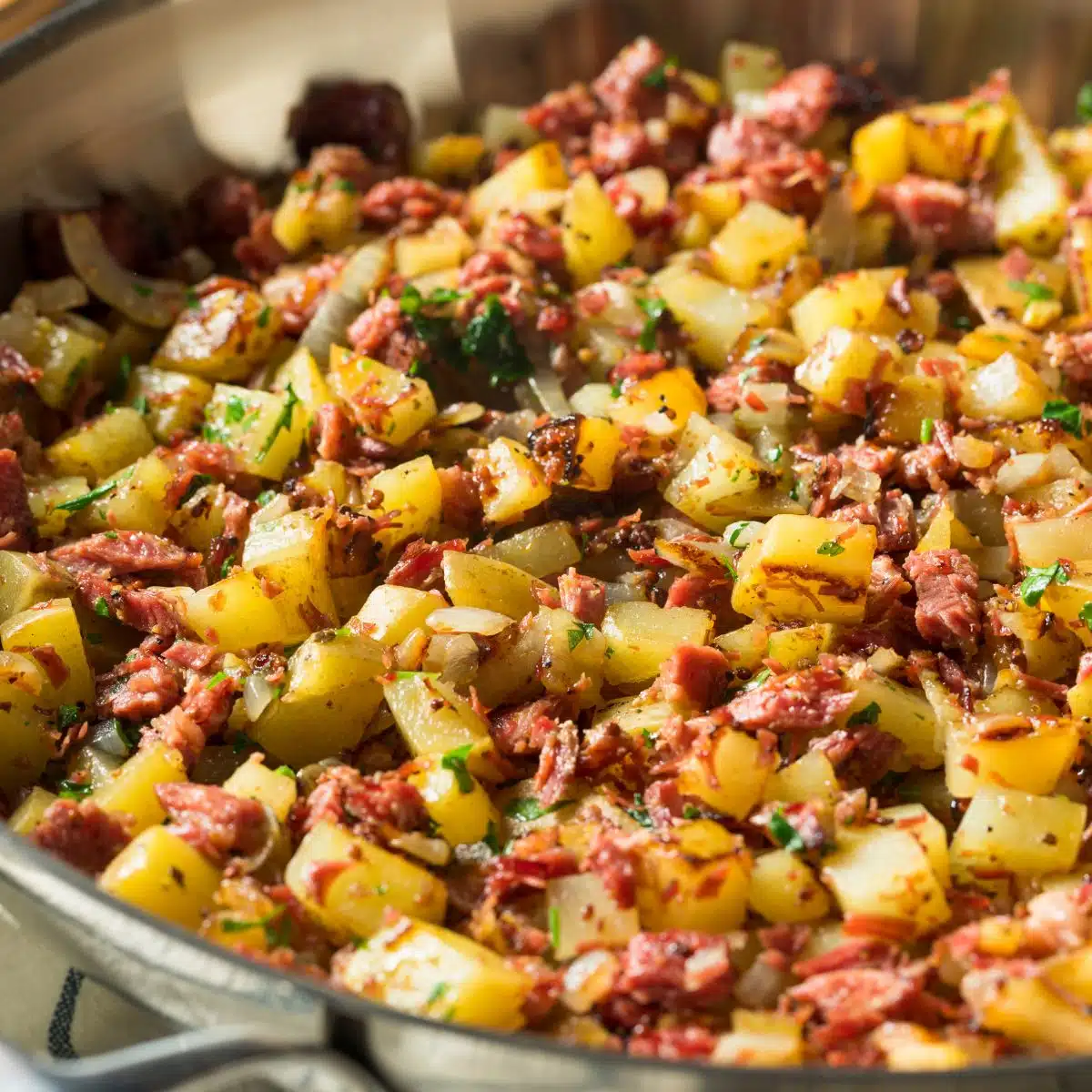 Square image of corned beef hash in a pan.
