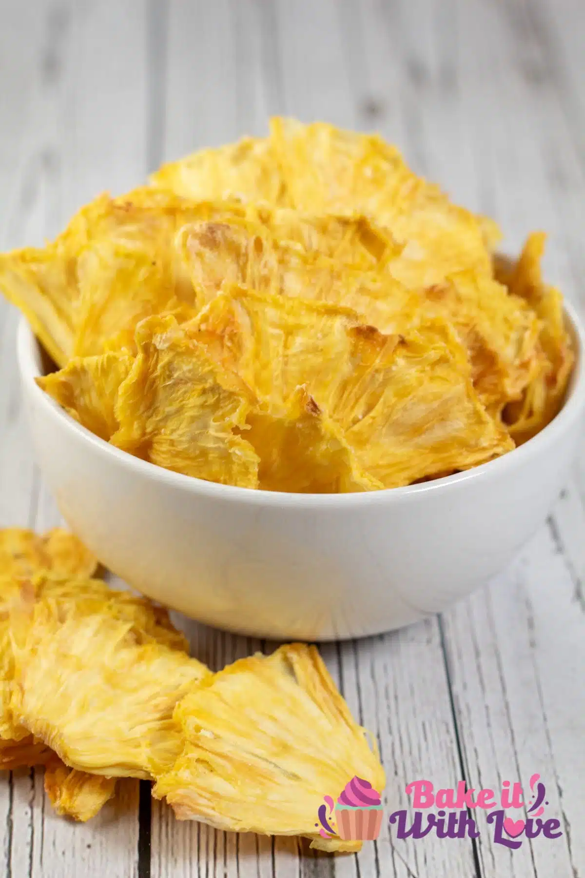Tall image showing dehydrated pineapple chips.