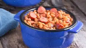 Wide image of a pot of franks and beans.