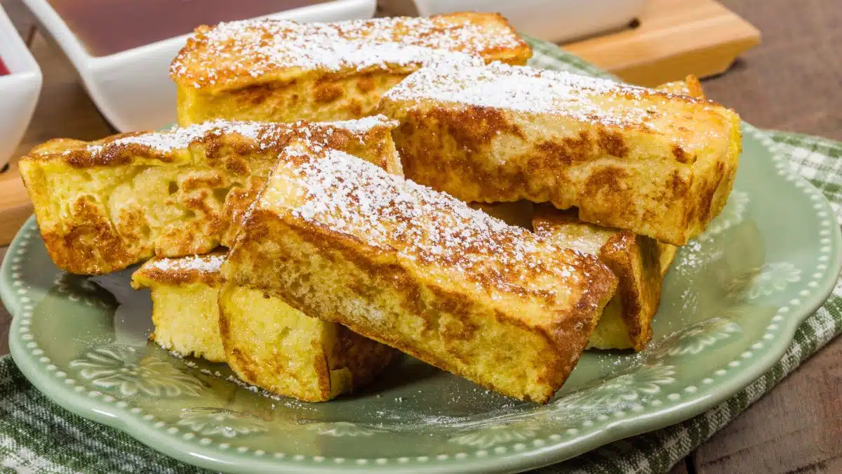 Wide image of French toast sticks on a plate.