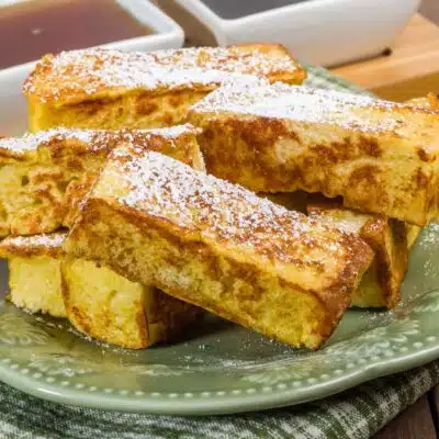 Square image of French toast sticks on a plate.