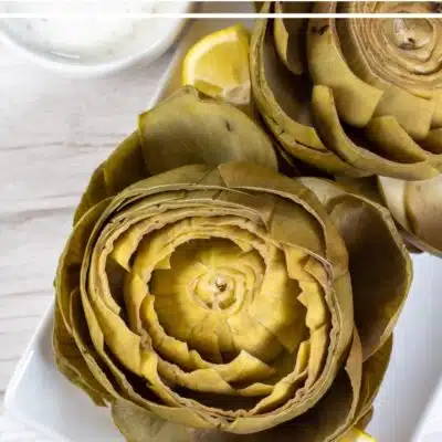 Pin image with text of instant pot artichokes on a white plate.