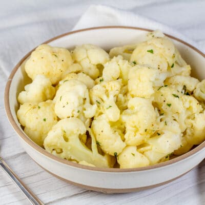 Square image of a bowl with instant pot cooked cauliflower.