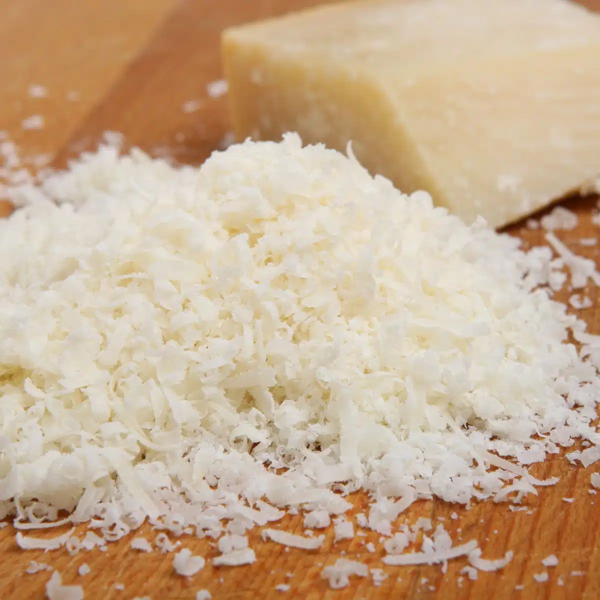 Square image of grated Romano cheese.