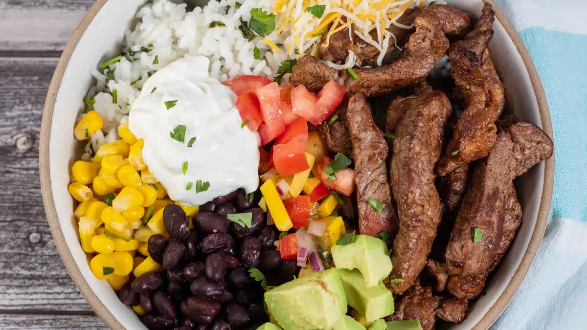 Wide overhead image of a steak burrito bowl.