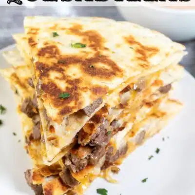 Pin image with text of sliced and stacked steak quesadillas.