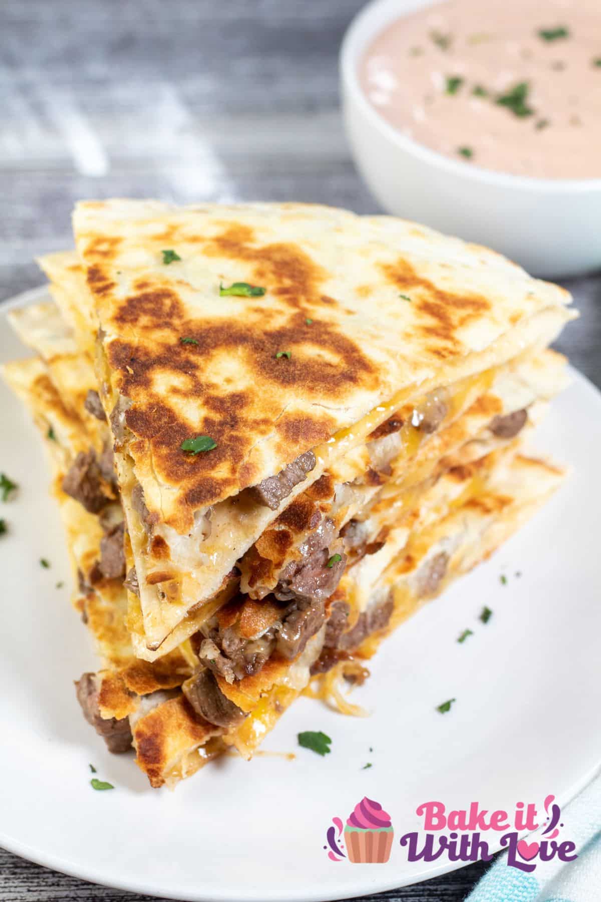 Tall image of sliced and stacked steak quesadillas.