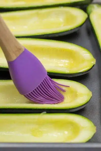 Process image 3 showing brushing olive on zucchini.