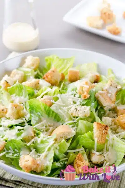 Tall image of Caesar Salad in a white bowl.