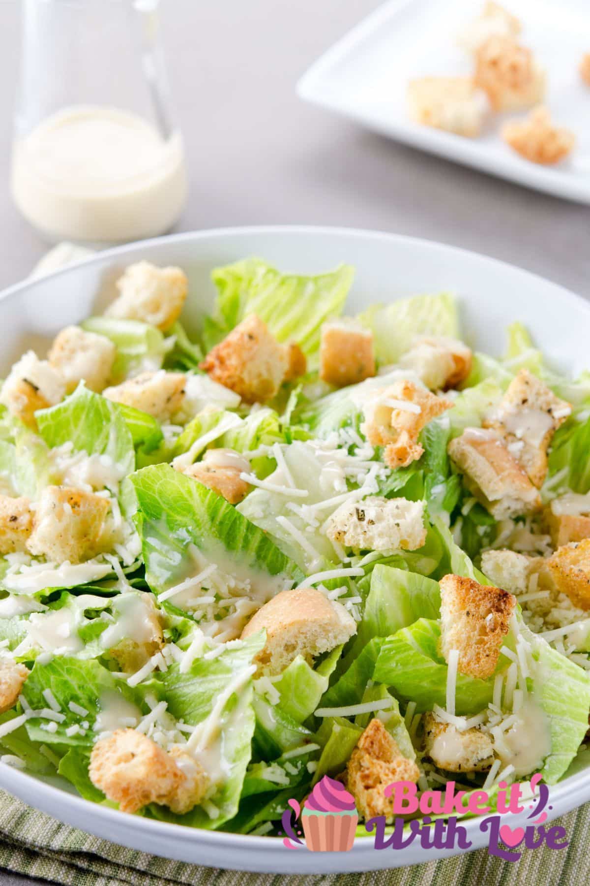Immagine alta di Caesar Salad in una ciotola bianca.