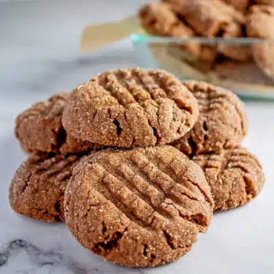 Tasty chocolate peanut butter cookies rolled in sugar and baked until tender then stacked on light marble background.