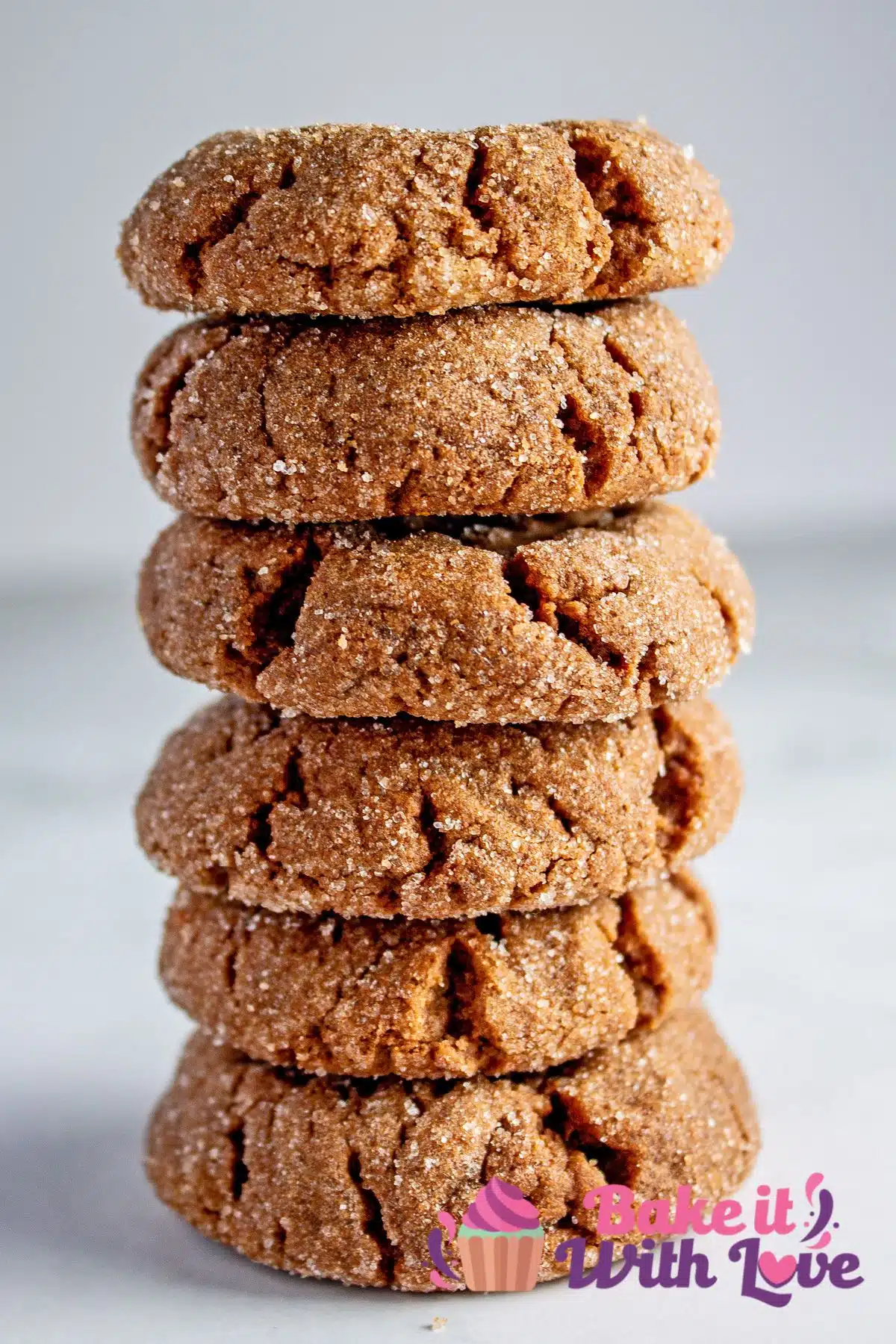 Tall closeup image of the baked chocolate peanut butter cookies stacked 5 cookies high on light grey marble background.