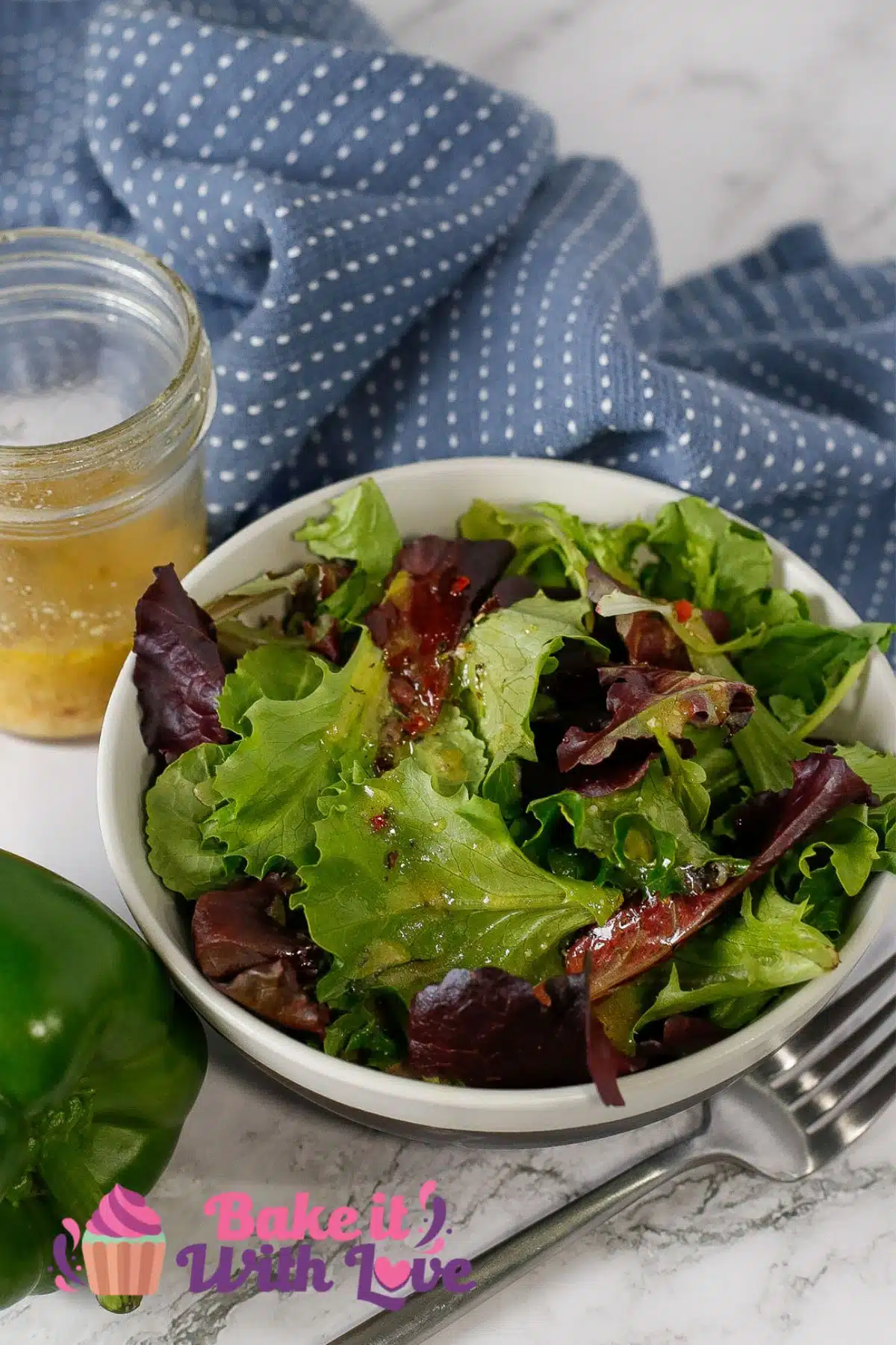Homemade Italian dressing recipe served with greens and the jar of salad dressing in the background.