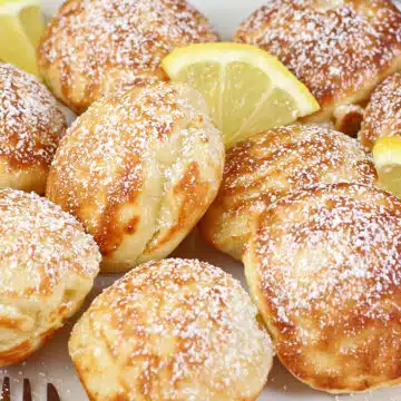 Puffed Dutch mini pancakes (poffertjes) are a tasty yeast-based pancake shaped like a UFO and served with butter, powdered sugar, and lemon.