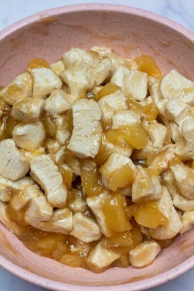Обработете изображение 8, показващо нарязани бисквити в купа за смесване с добавена смес за ябълков пай.