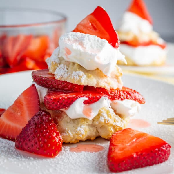 Firkantet billede af Bisquick strawberry shortcake på en hvid tallerken.