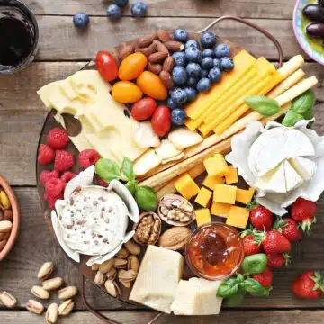 Wide image showing a cheese platter with extras.
