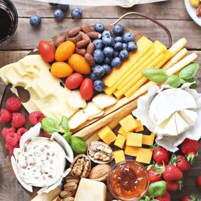 Pin image with text showing a cheese platter with extras.