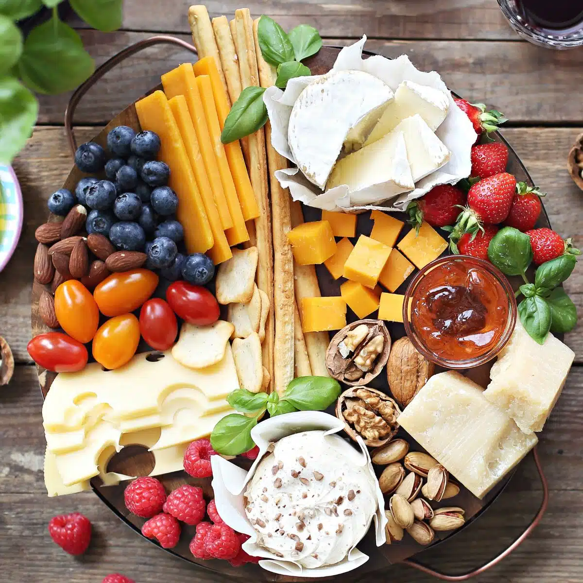 Square image showing a cheese platter with extras.