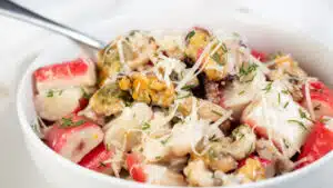 Wide image of creamy seafood mix in a white bowl.