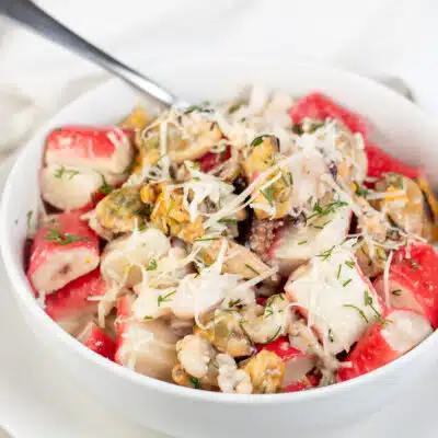 Square image of creamy seafood mix in a white bowl.
