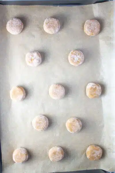 Process image 9 showing chilled dough coated in sugar pressed down and on a baking sheet.