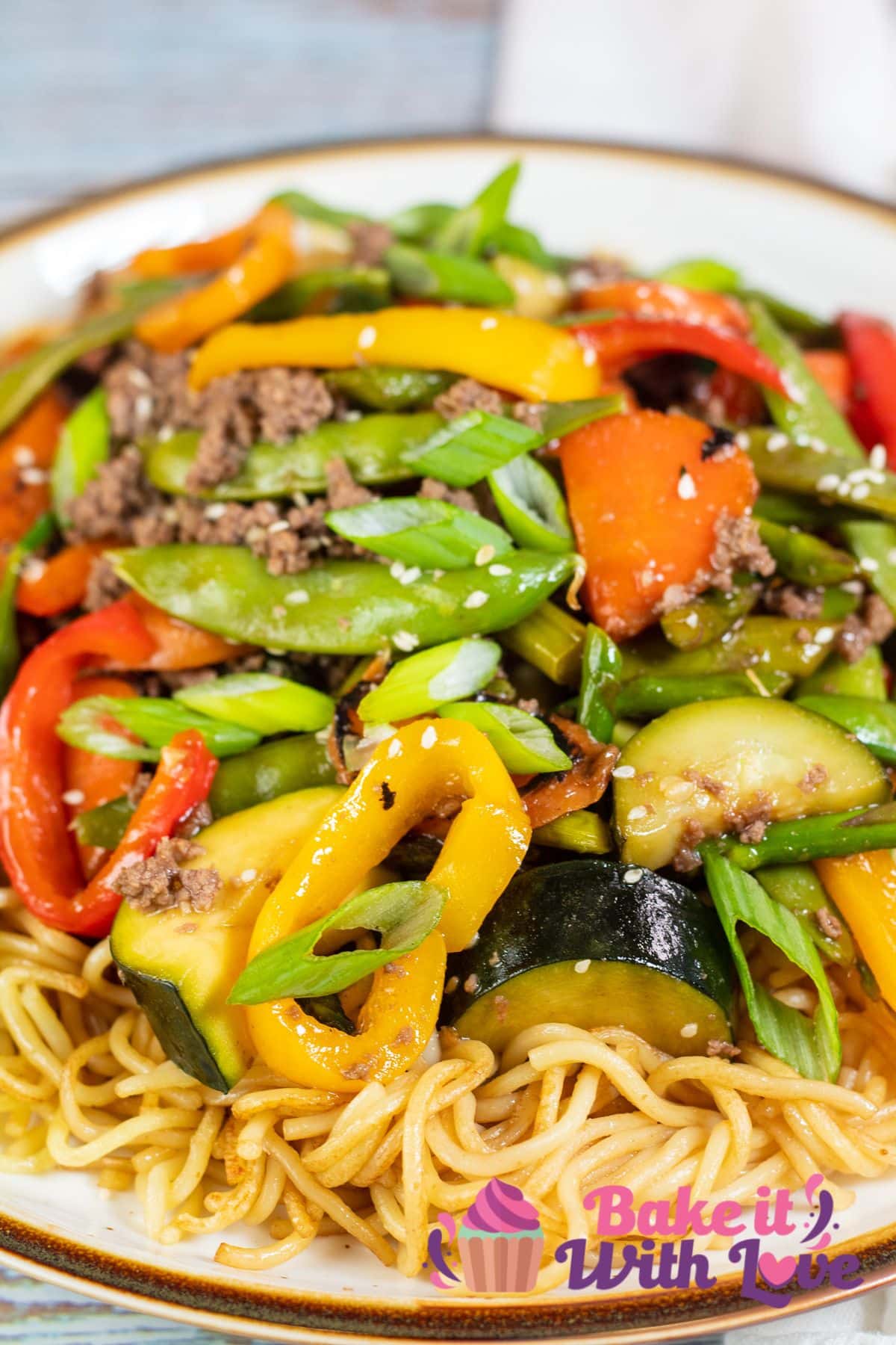 Tall image showing ground beef stir fry with noodles.
