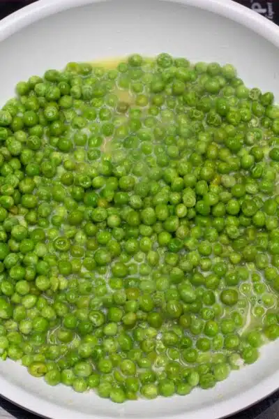 Process image 2 showing frozen peas cooking in a skillet.