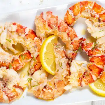 Wide image showing butter poached lobster tails.