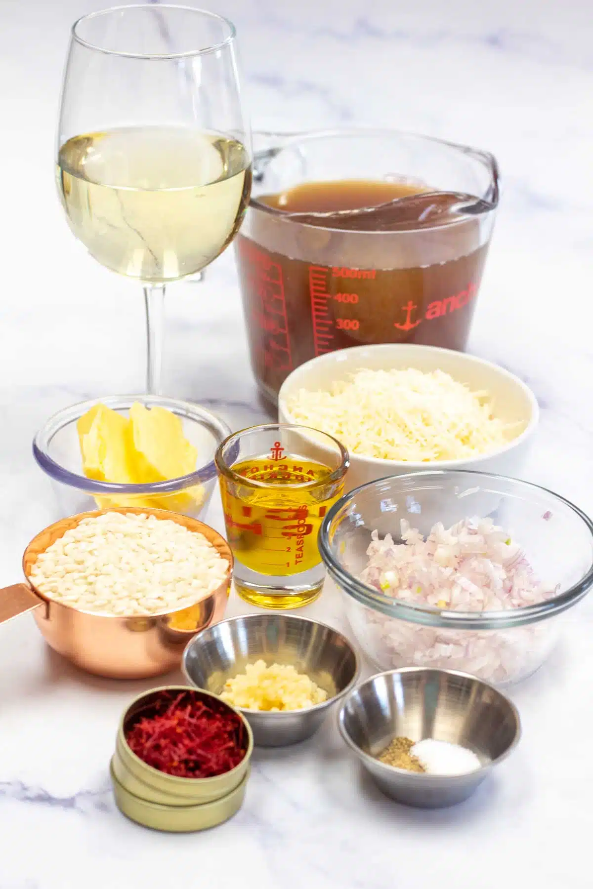 Tall image showing ingredients needed for saffron risotto.