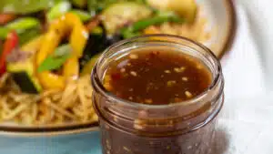 Wide image showing a glass jar of stir fry sauce.