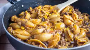 Wide image of taco pasta in a large skillet.