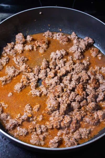 Process image 3 showing added water and seasoning to ground beef.