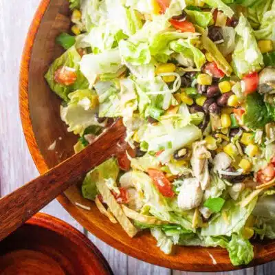Pin image with text of a Tex-Mex salad in a wooden bowl.
